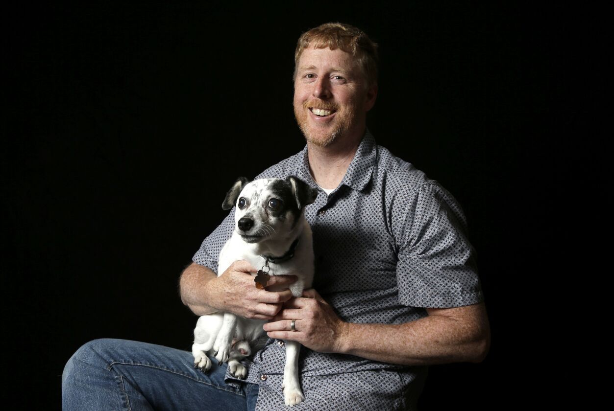 In this Monday, June 8, 2015 photo, photographer Fred Levy poses with his dog, a 12-year-old rat terrier named Toby, for a photograph at his home, in Maynard, Mass. | Steven Senne / AP